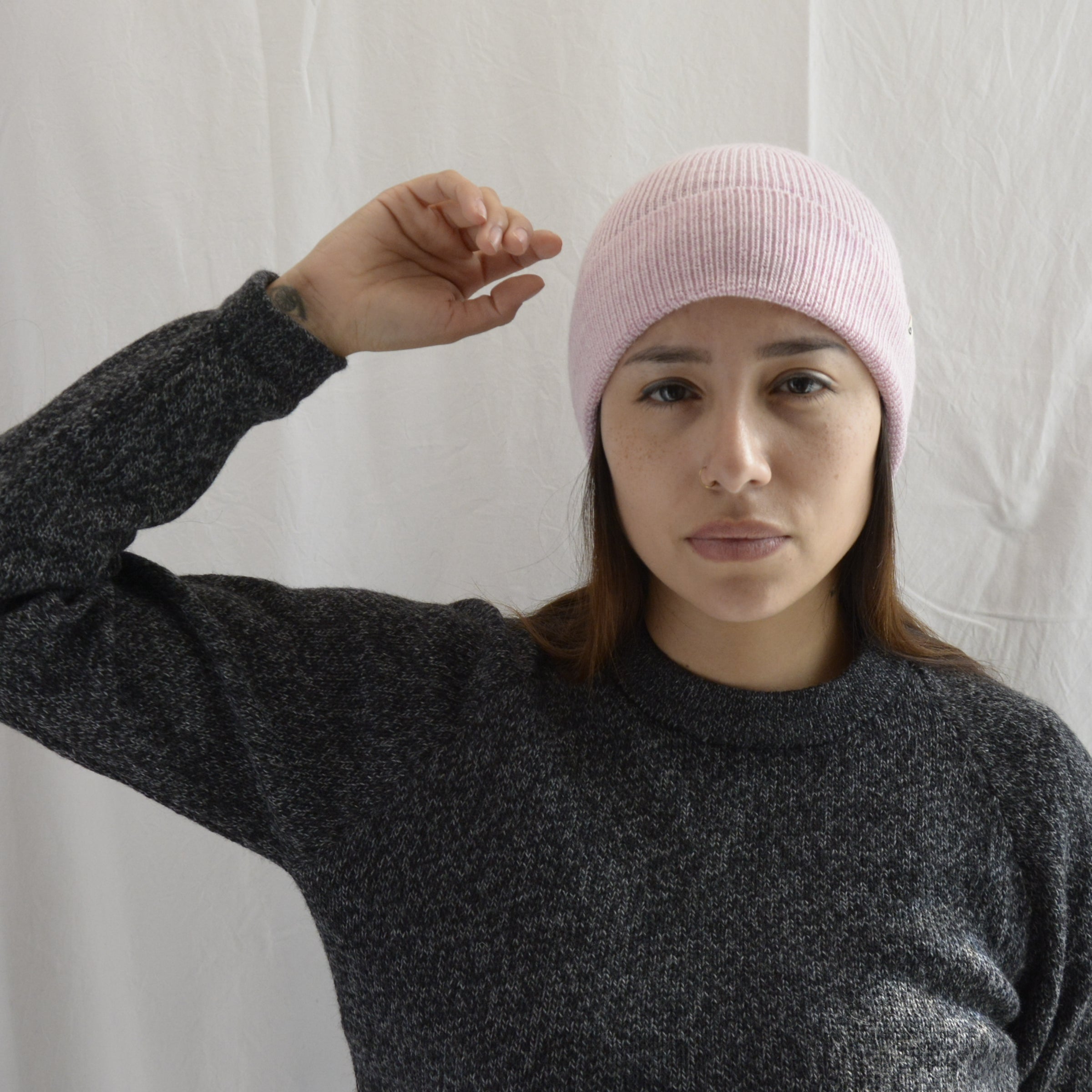 Woman_wearing_alpaca_en_peru_pink_beanie_and_gray_round_neck_sweater_with_arm_up