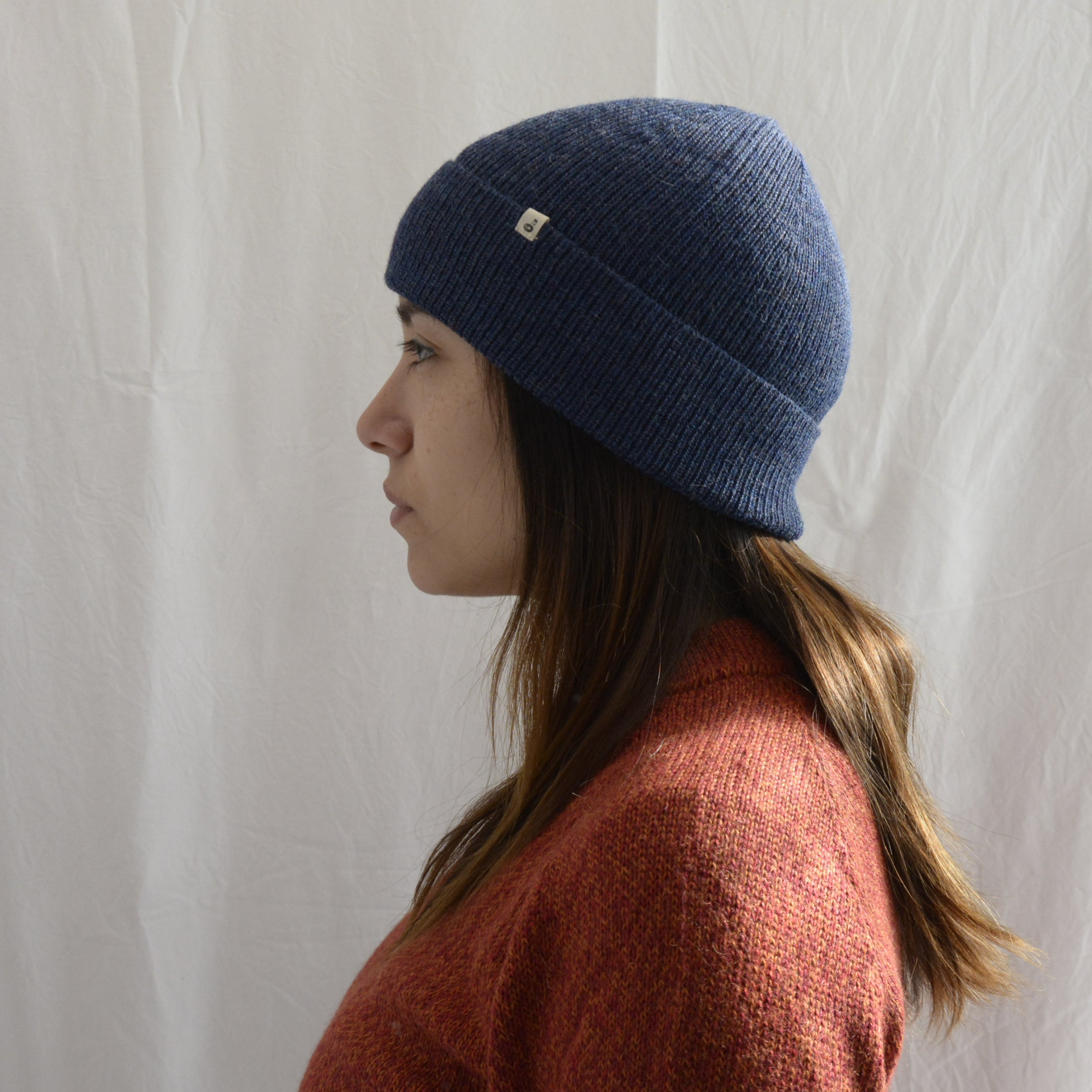 Woman_wearing_alpaca_en_peru_steel_blue_beanie_and_orange_round_neck_sweater