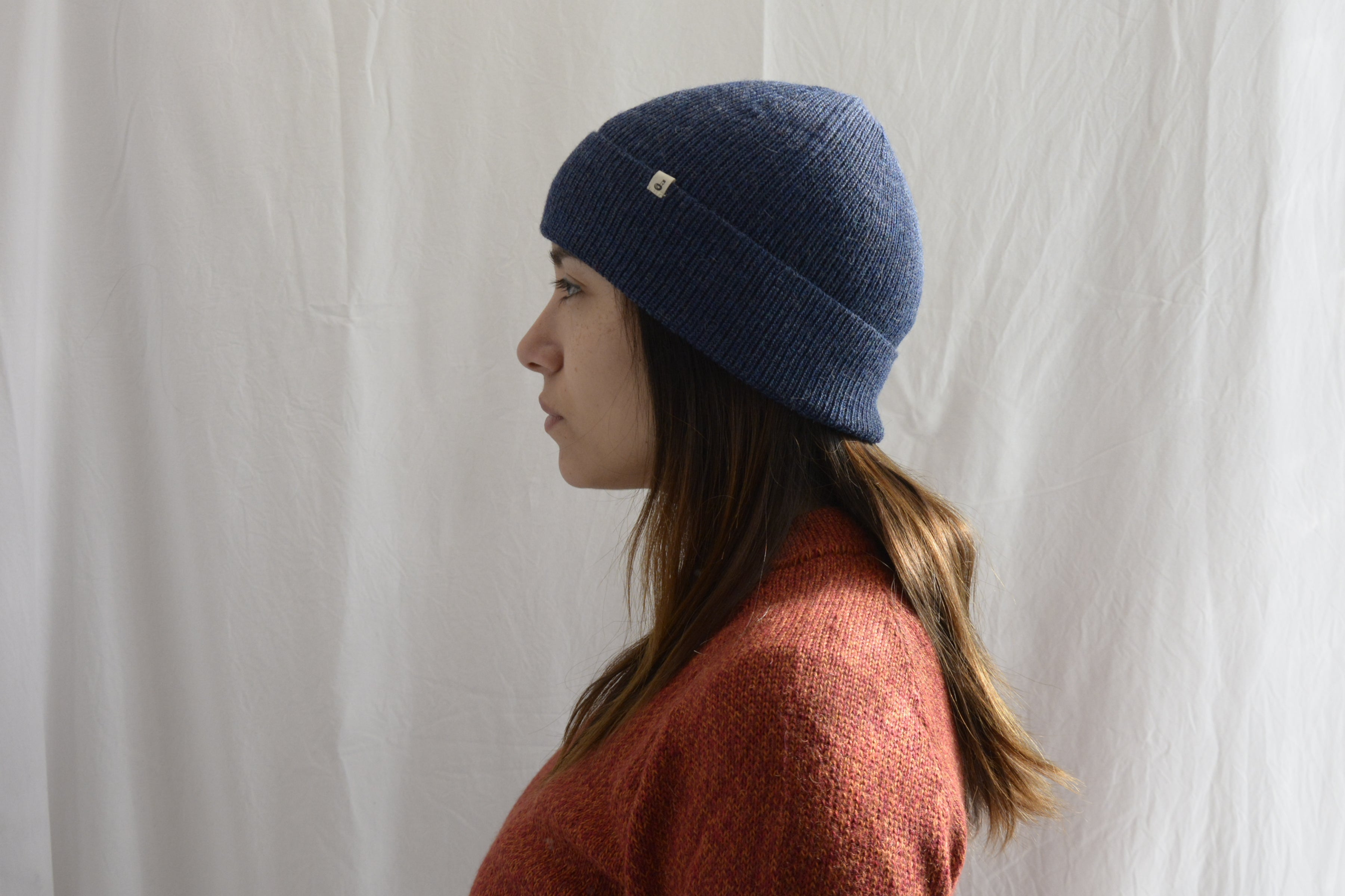 Woman_wearing_alpaca_en_peru_steel_blue_beanie_and_orange_round_neck_sweater