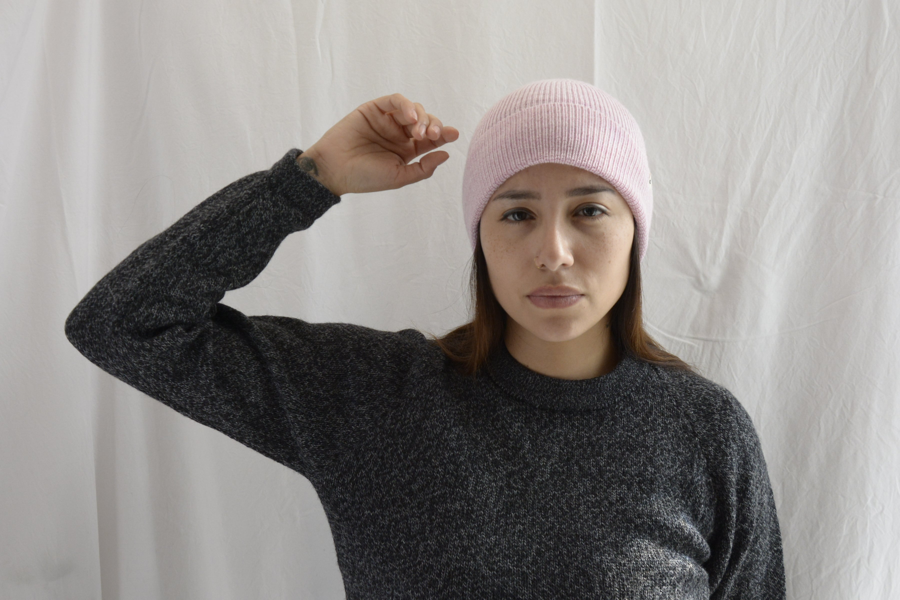 Woman_wearing_alpaca_en_peru_pink_beanie_and_gray_round_neck_sweater_with_arm_up