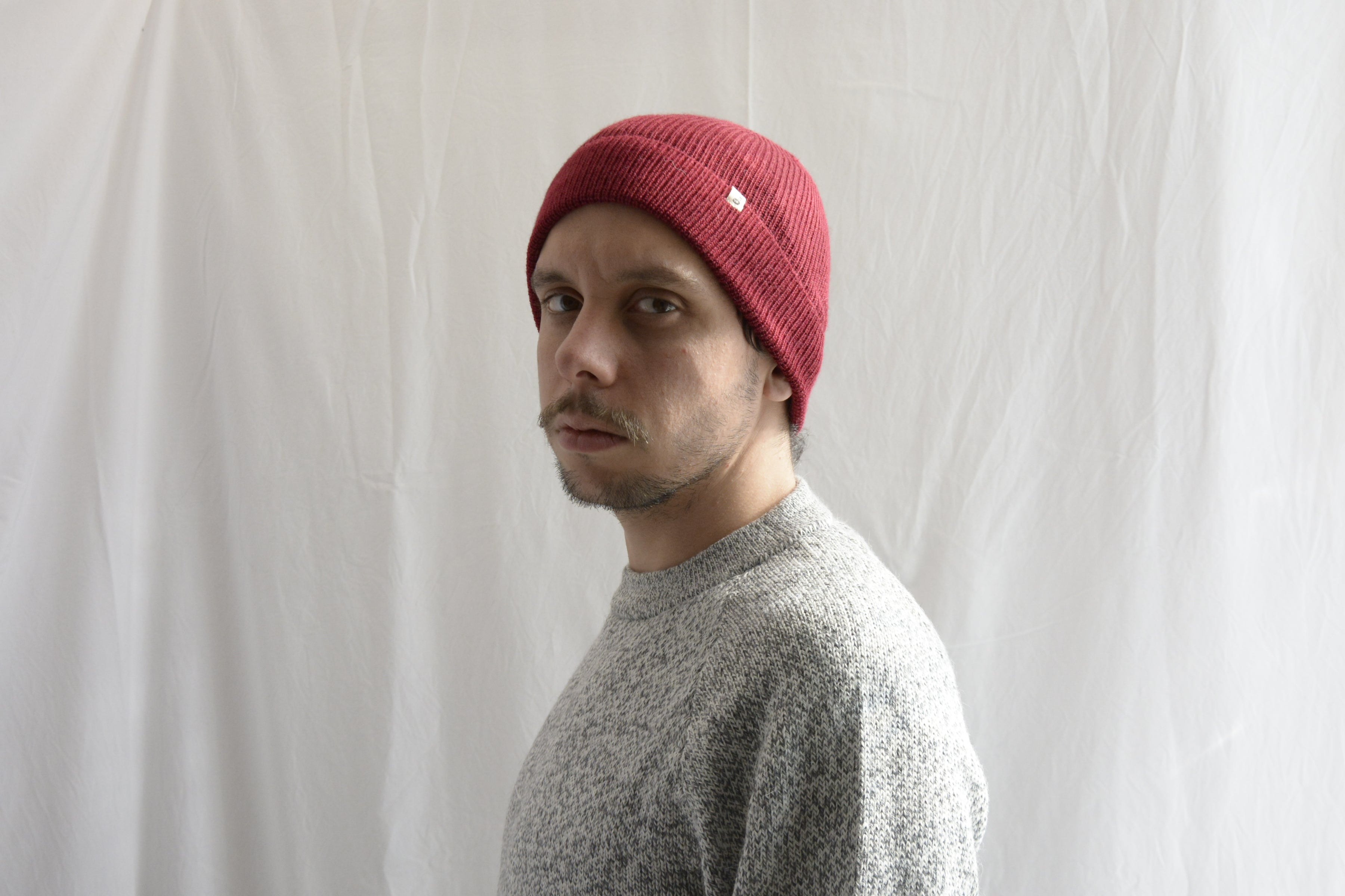 Man_wearing_brick_red_beanie_and_light_gray_sweater_alpaca_clothing